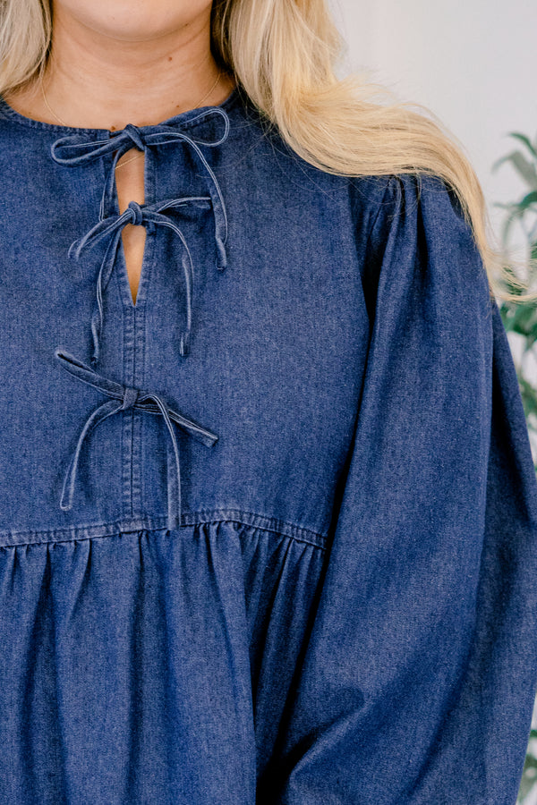 Chic Soul plus size clothing, dark wash denim long puff sleeve knee length baby doll dress with v neck cutout and strings tying in 3 bows down the collar