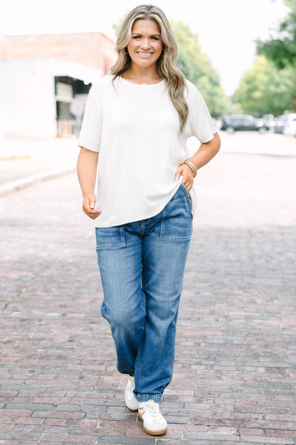 Plus Size medium wash high-rise cargo jogger jeans with front patch pockets and elasticized cuffs.