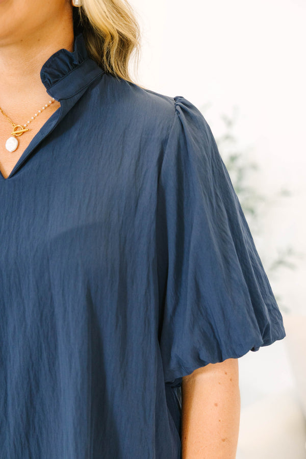 Plus Size navy blue rayon-blend top with a v-neckline, ruffled collar, and puff elbow-length sleeves.