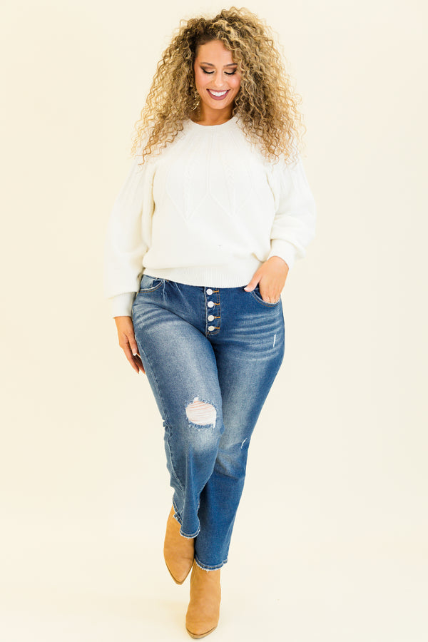 mid-waisted subtle flare cropped dark wash denim jeans with slight distressed detailing along knees and multiple silver buttons on waistline 
