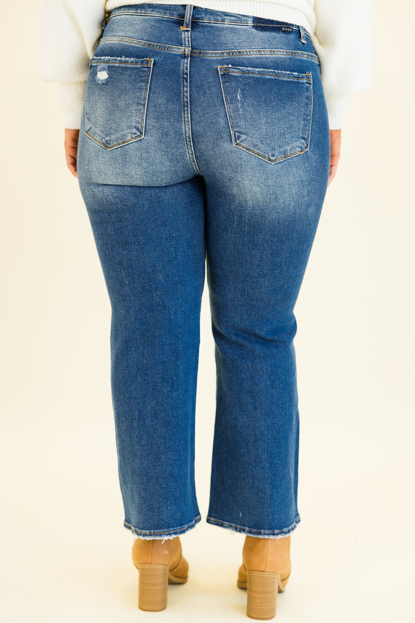 mid-waisted subtle flare cropped dark wash denim jeans with slight distressed detailing along knees and multiple silver buttons on waistline 
