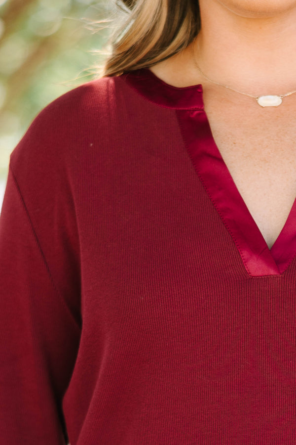 Plus Size burgundy long sleeve top with a ribbed texture and a satin-trimmed v-neckline.