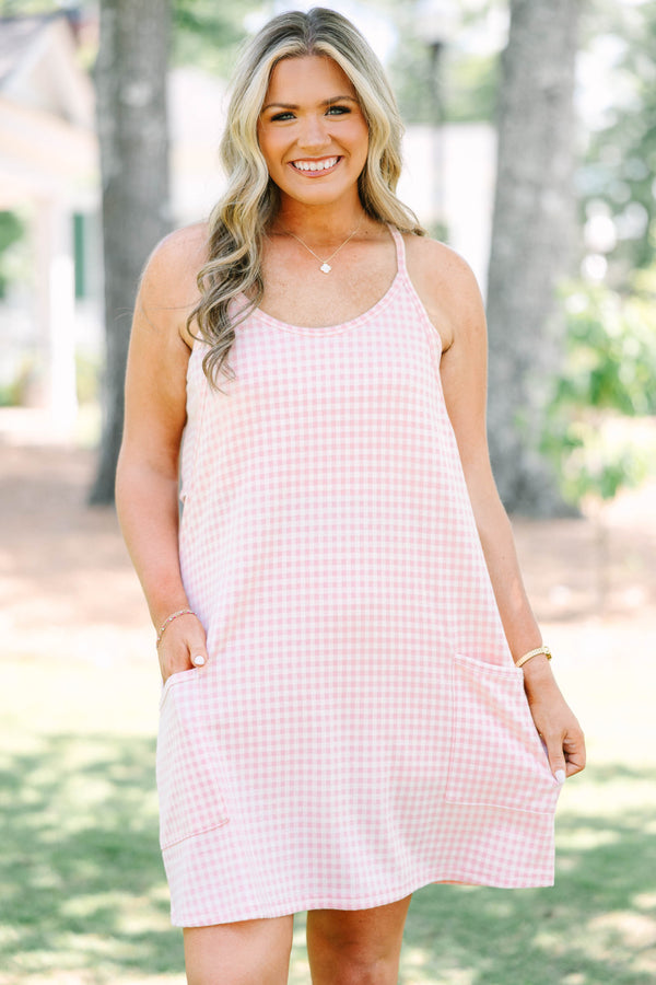 Plus size pink gingham athleisure dress with front pockets and a flowy, comfortable fit.