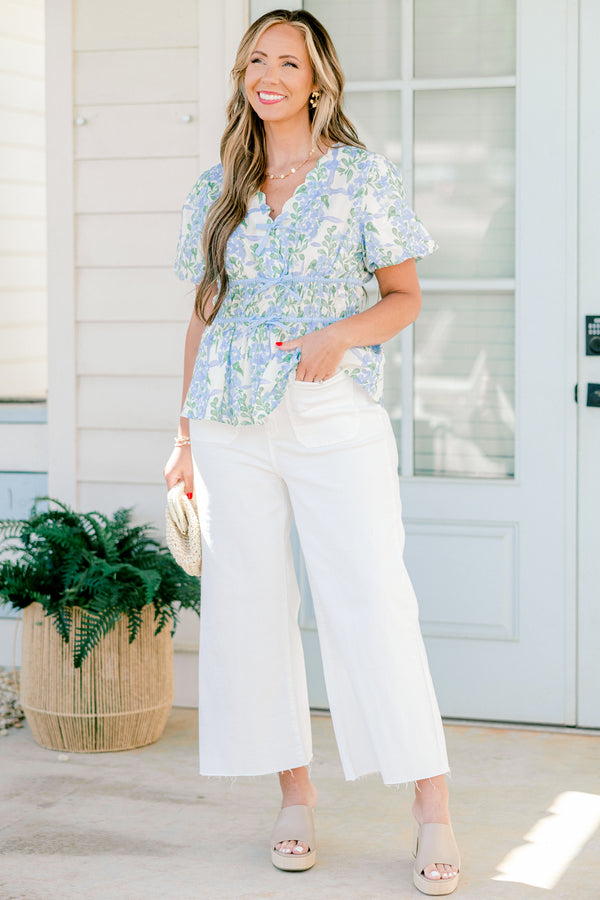 Chic soul plus size clothing, blue short sleeve babydoll top with a floral pattern and a scalloped v-neckline as well as three tie bows going down the  chest 

