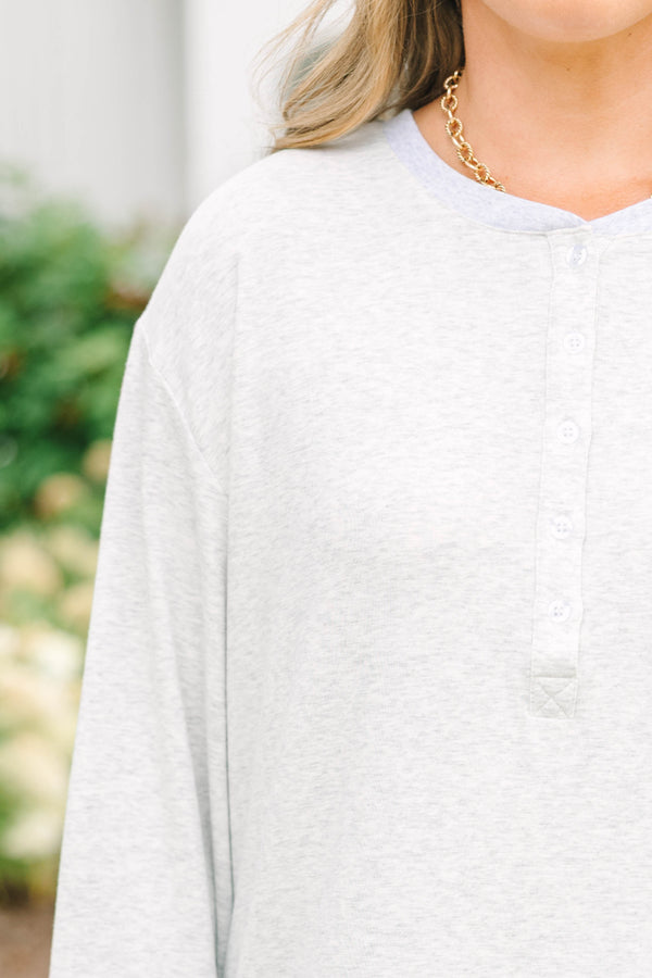 Heather grey oversized knit henley top with a button placket and dropped shoulders.