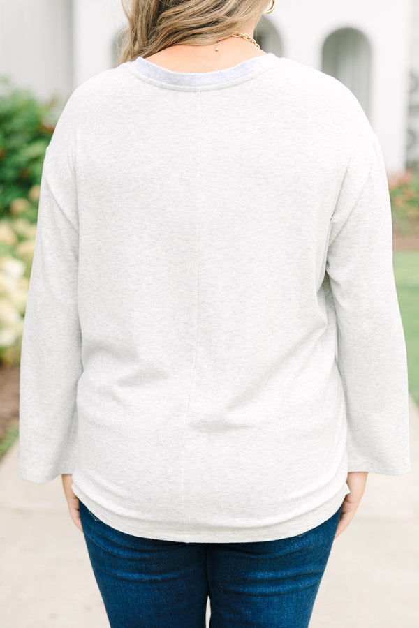 Heather grey oversized knit henley top with a button placket and dropped shoulders.
