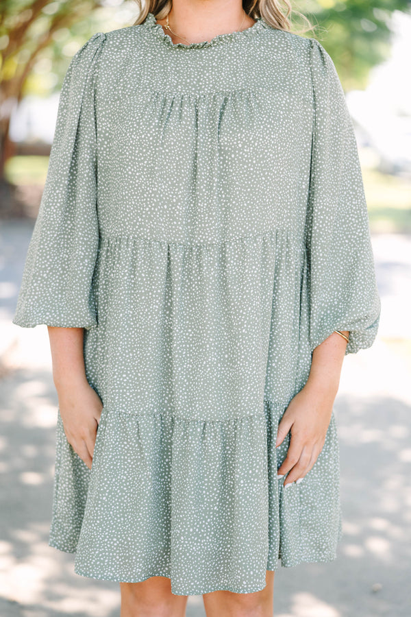 Plus size olive green tiered mini dress with white polka dots and a flowy, relaxed fit.