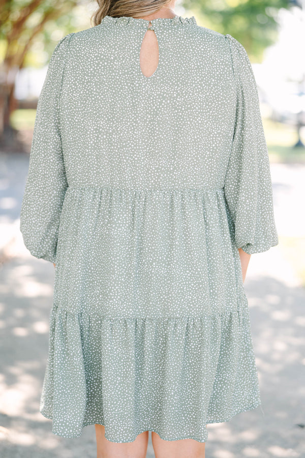Plus size olive green tiered mini dress with white polka dots and a flowy, relaxed fit.