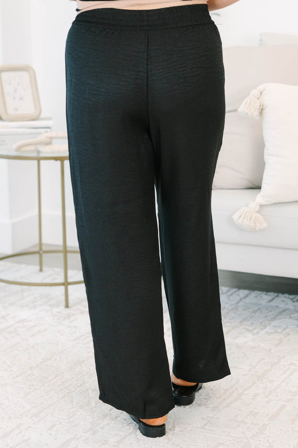 Plus size black wide-leg pants with a comfortable elastic waist and flowy, textured fabric.
