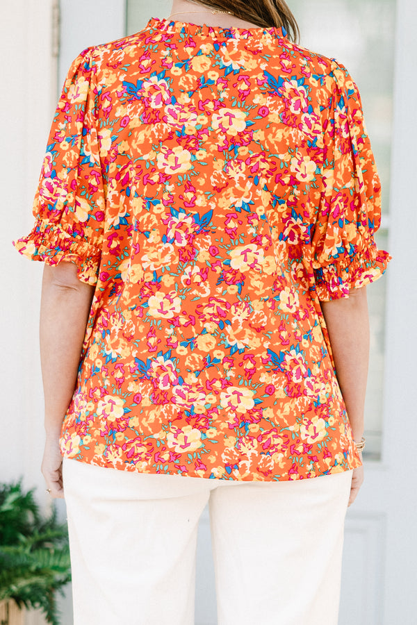 Chic soul plus size clothing, Orange top with three quarter length sleeves, multi-color floral pattern, and a partial ruffle collar 