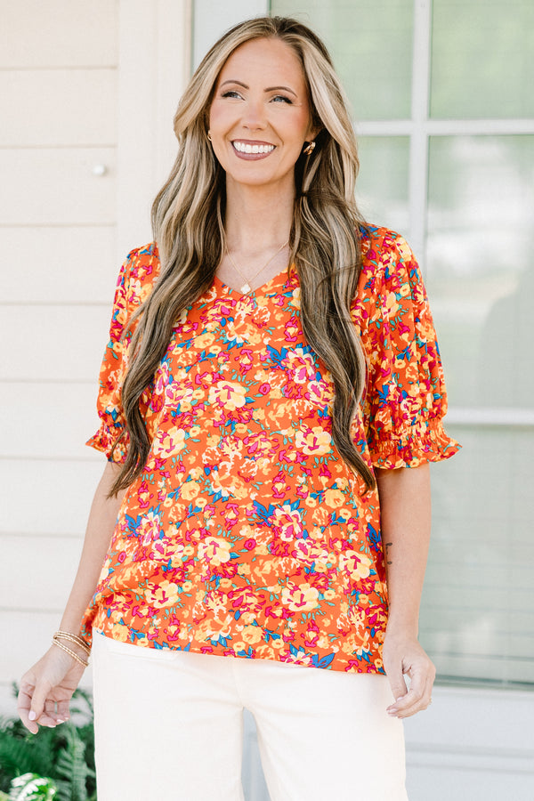 Chic soul plus size clothing, Orange top with three quarter length sleeves, multi-color floral pattern, and a partial ruffle collar 