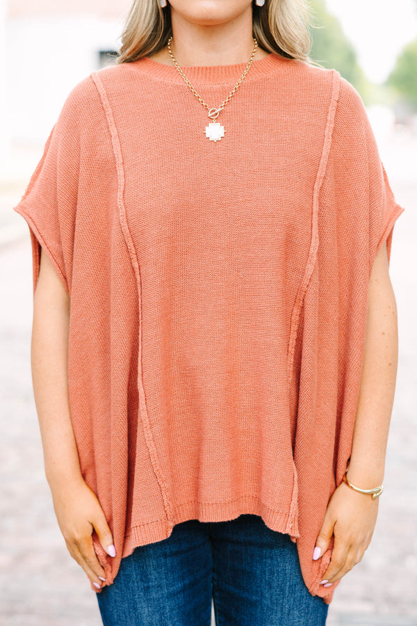 Plus size rust-colored, flowy knit sweater with a relaxed fit and short poncho sleeves.