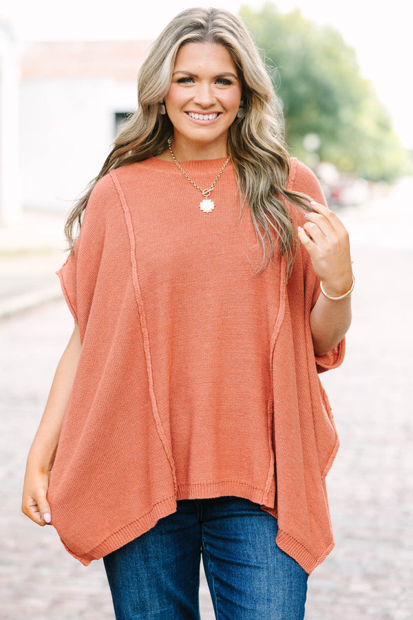 Plus size rust-colored, flowy knit sweater with a relaxed fit and short poncho sleeves.