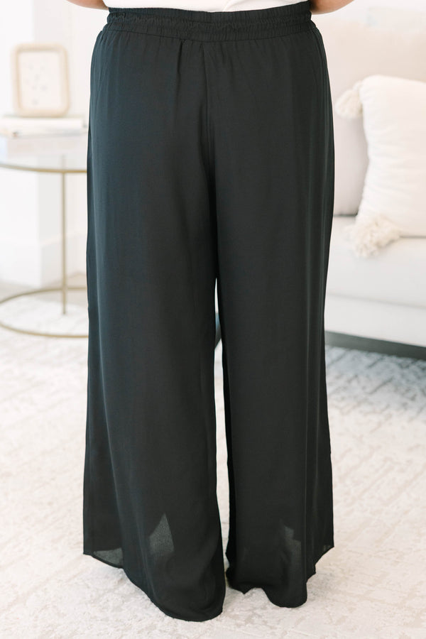 Plus size black wide-leg pants with a flowy fit, smocked drawstring waist, and tassel details.
