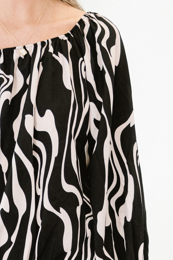 Chic Soul plus size clothing, long-sleeve black top with a scoop-neckline and a white marble abstract pattern with smocked detailing on the wrist of the sleeves 