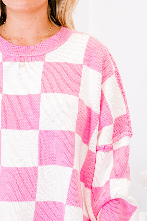 long-sleeve pink and cream checkered sweater with crew neckline and subtly distressed stitching 