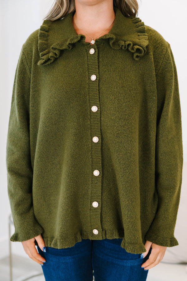Plus size olive green cardigan with a ruffled collar, pearl buttons, and a flowy, relaxed fit.