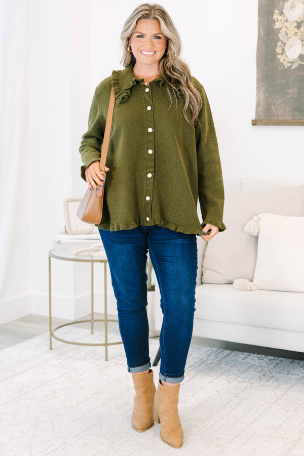 Plus size olive green cardigan with a ruffled collar, pearl buttons, and a flowy, relaxed fit.