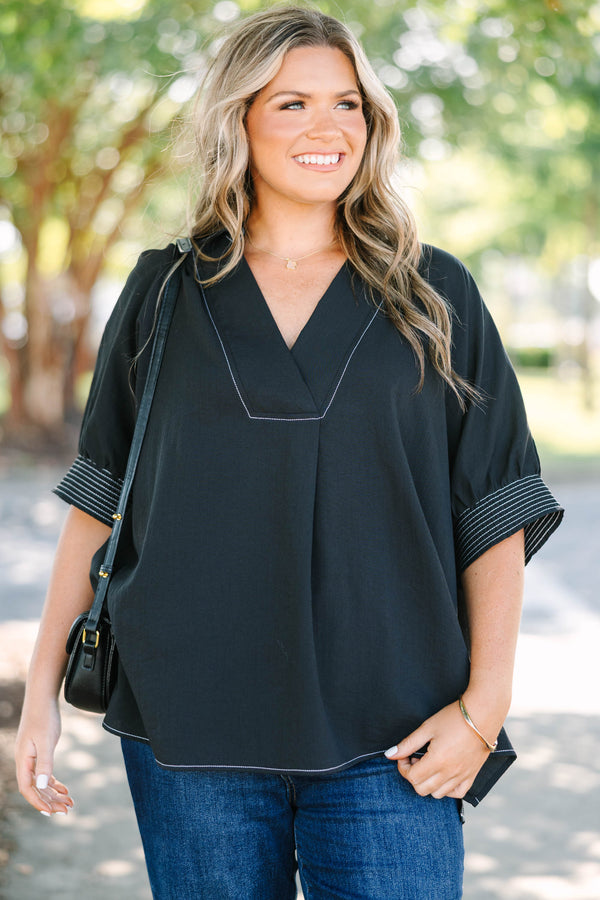 Plus Size black v-neck top with white contrast stitching on the neckline, cuffs, and hem.