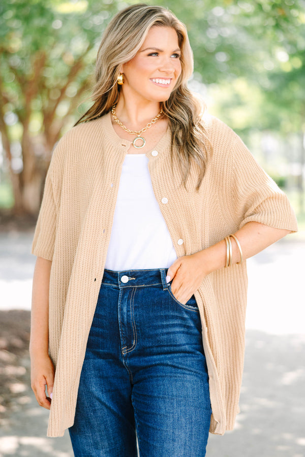 Plus size woman in a tan, short-sleeve knit cardigan with a flowy fit and button-down front.