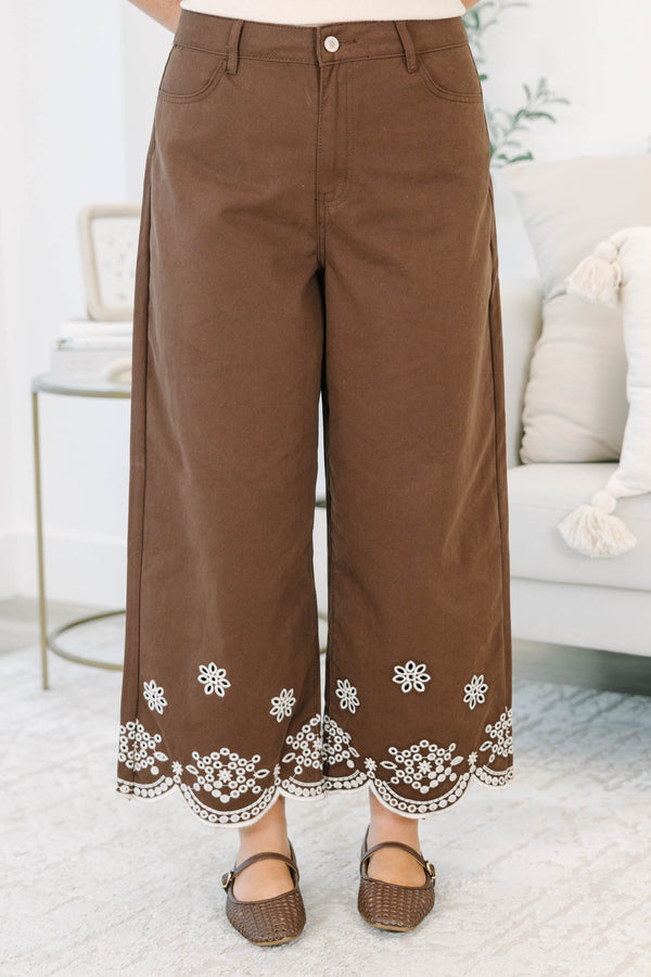 Plus Size brown high-rise wide-leg jeans with white floral embroidery and scalloped eyelet hems.