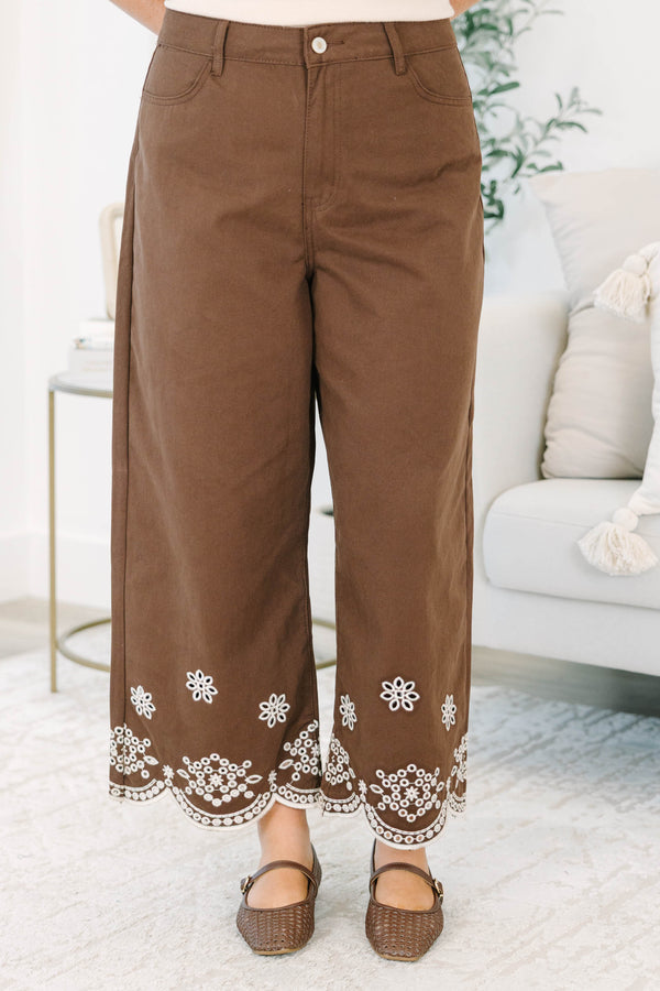 Plus Size brown high-rise wide-leg jeans with white floral embroidery and scalloped eyelet hems.