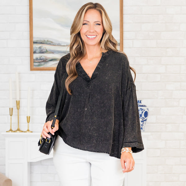 Plus Size black mineral wash top with a v-neckline, oversized fit, and cuffed wide sleeves.
