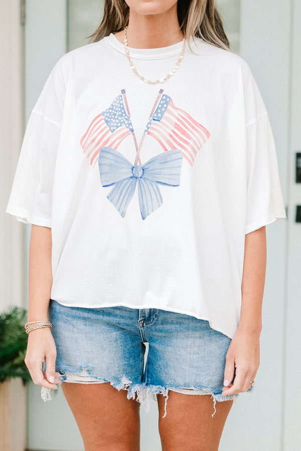 Plus Size white vintage wash tee with an American flag and blue bow graphic and unfinished hems.
