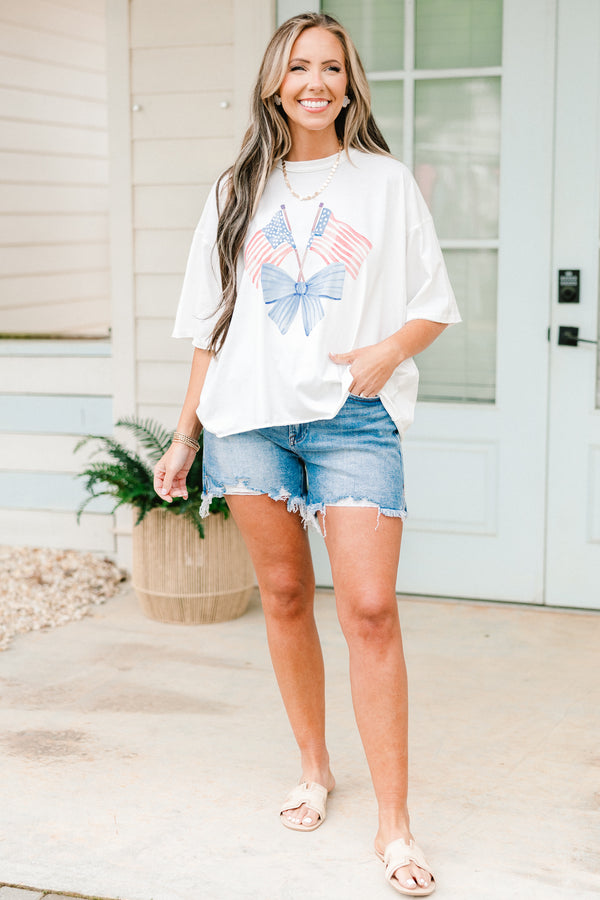 Plus Size white vintage wash tee with an American flag and blue bow graphic and unfinished hems.