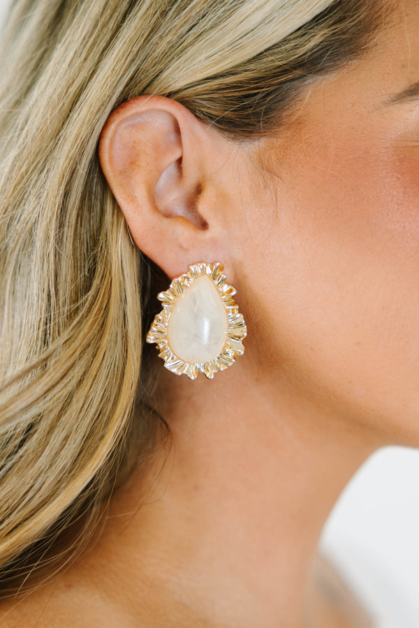 Gold statement earrings with a teardrop white stone and rippled gold border.