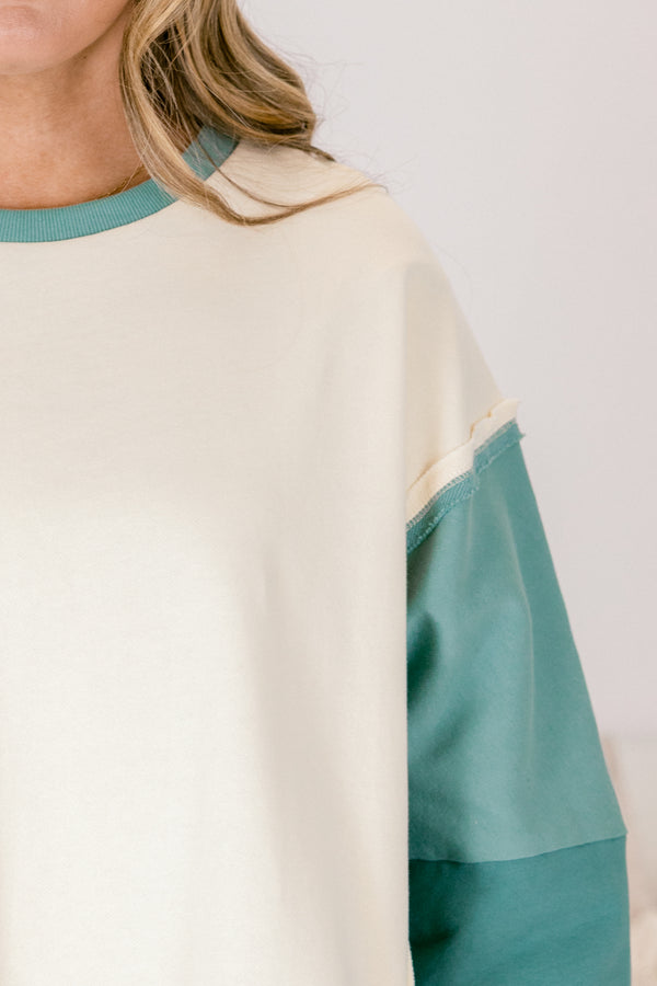 Chic Soul plus size clothing, cream long sleeve pullover over, with two different green accents on the sleeves as well as going along the sides and bottom of the pullover and across the neckline