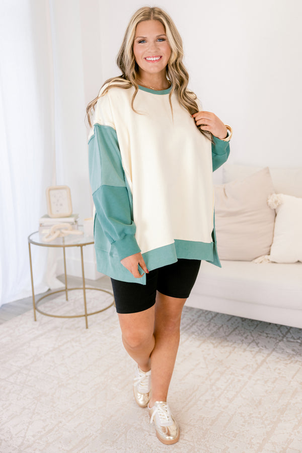 Chic Soul plus size clothing, cream long sleeve pullover over, with two different green accents on the sleeves as well as going along the sides and bottom of the pullover and across the neckline