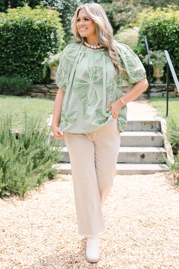 Plus Size olive top with white floral embroidery, elastic puff sleeves, and a round neckline.