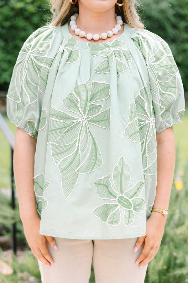 Plus Size olive top with white floral embroidery, elastic puff sleeves, and a round neckline.