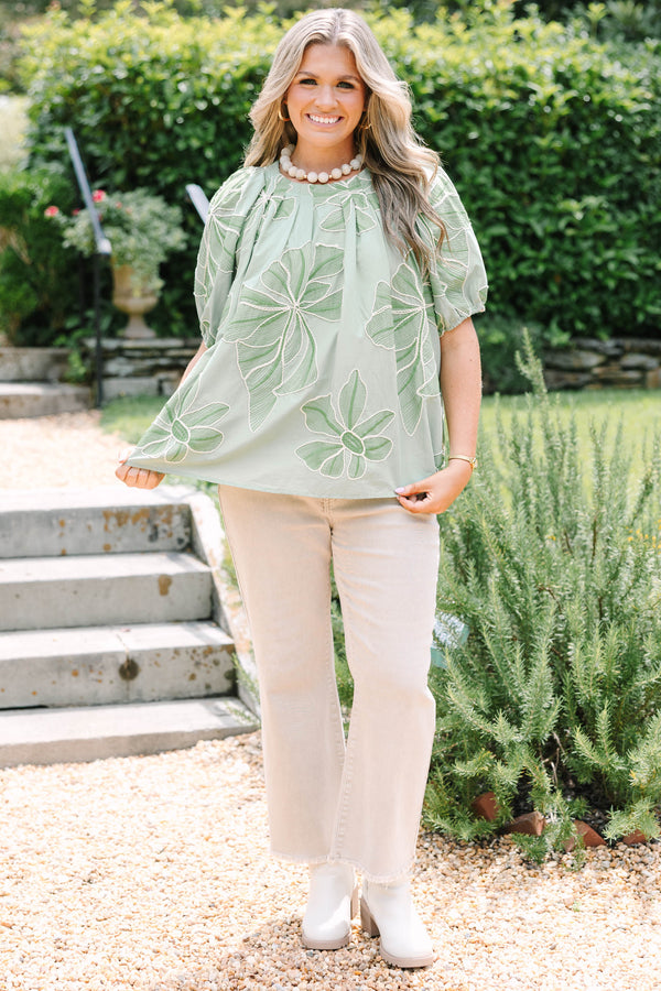 Plus Size olive top with white floral embroidery, elastic puff sleeves, and a round neckline.