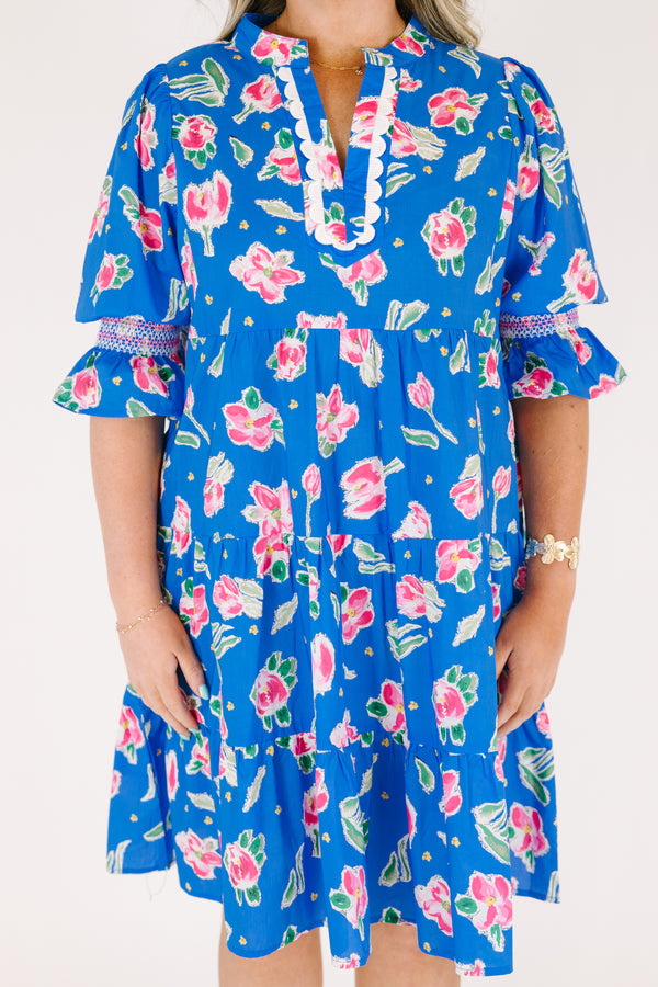 Chic Soul plus size clothing, cobalt tiered knee length dress with half sleeves that have a ruffle flare at the end of each sleeve as well as a pink floral pattern throughout and scalloped detailing on the v-neckline 