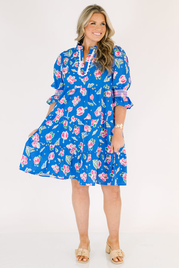 Chic Soul plus size clothing, cobalt tiered knee length dress with half sleeves that have a ruffle flare at the end of each sleeve as well as a pink floral pattern throughout and scalloped detailing on the v-neckline 