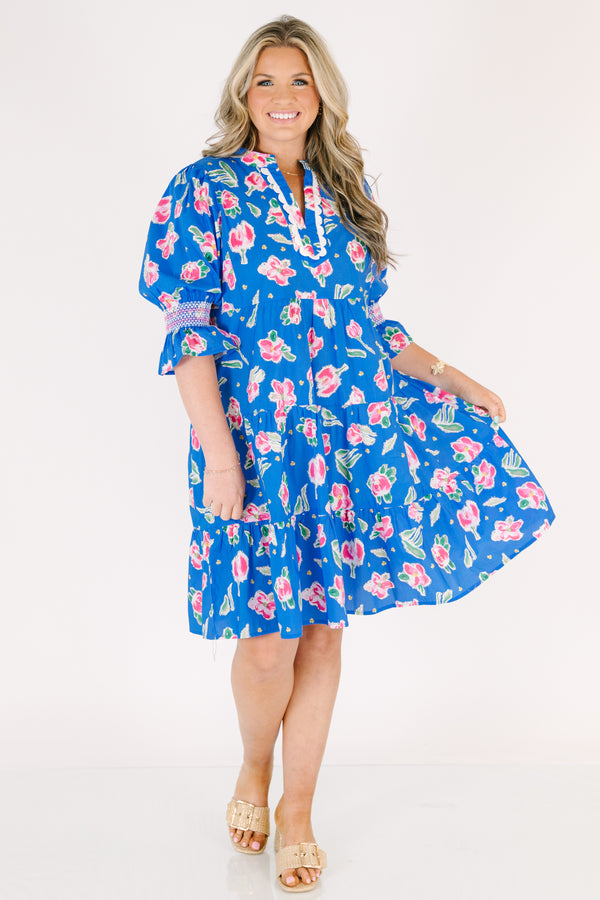 Chic Soul plus size clothing, cobalt tiered knee length dress with half sleeves that have a ruffle flare at the end of each sleeve as well as a pink floral pattern throughout and scalloped detailing on the v-neckline 