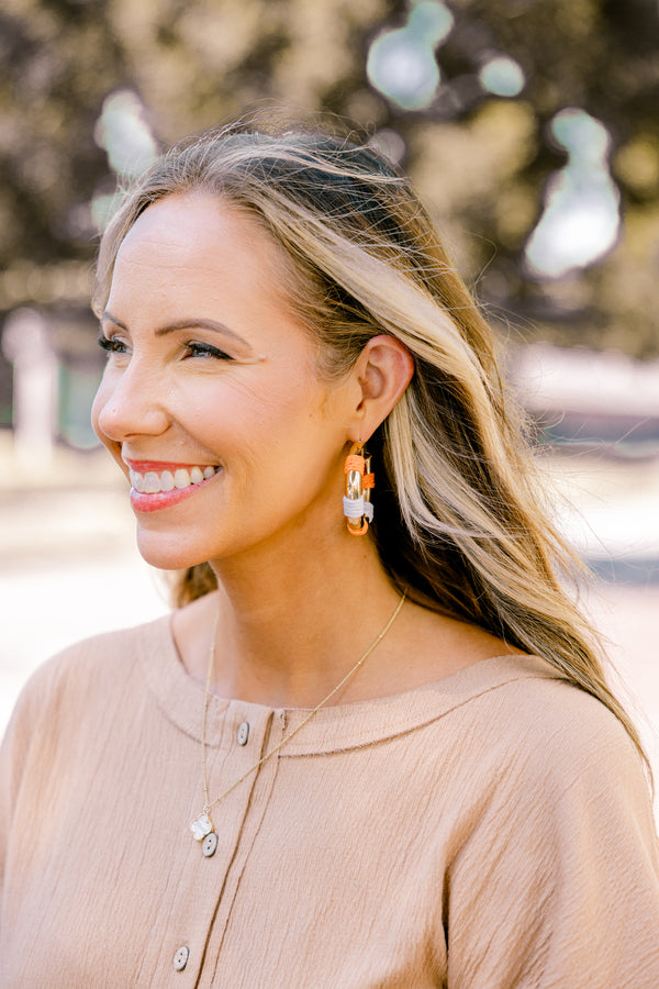 Chic Soul plus size clothing, gold hoop earrings with orange and white woven segments on each earring 