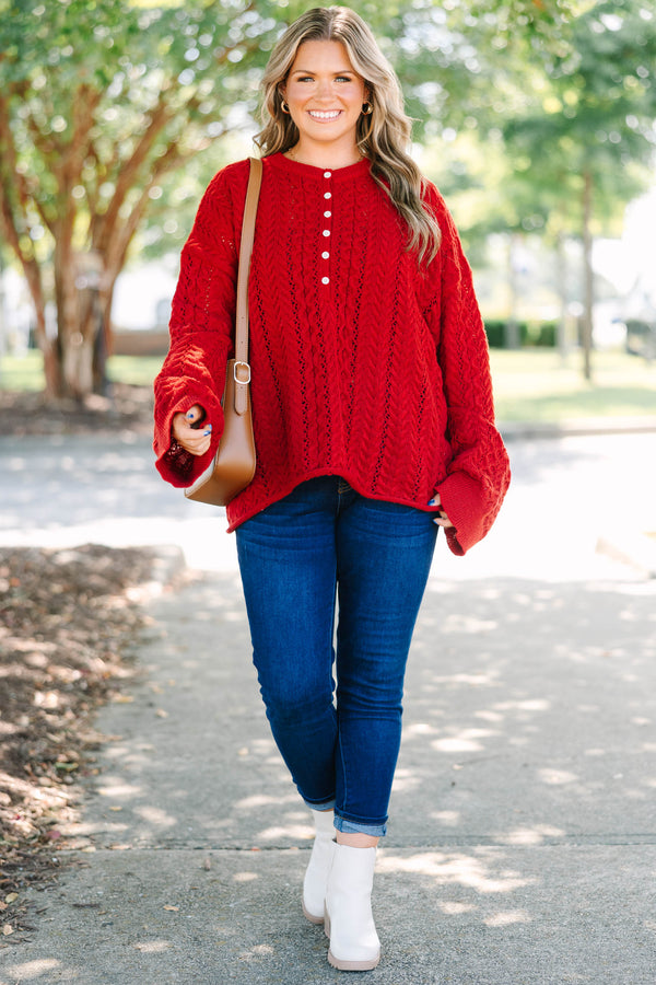 Plus size deep red cable knit sweater with a flowy fit, button-up neckline, and wide sleeves.