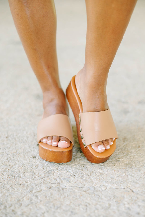 Brown mules with a faux leather strap and wooden platform sole.