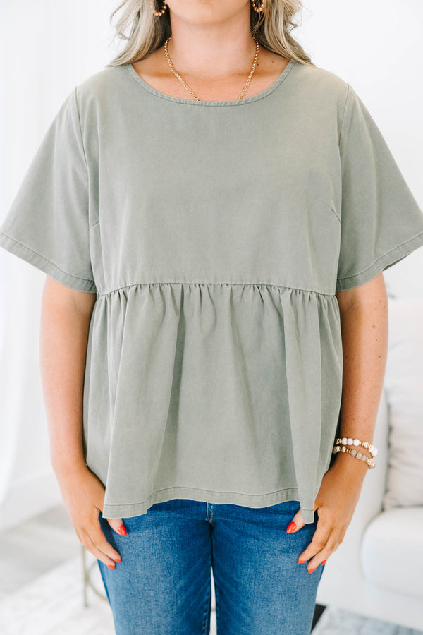 Plus Size olive green short sleeve babydoll top with a round neckline and ruffled waist seam.