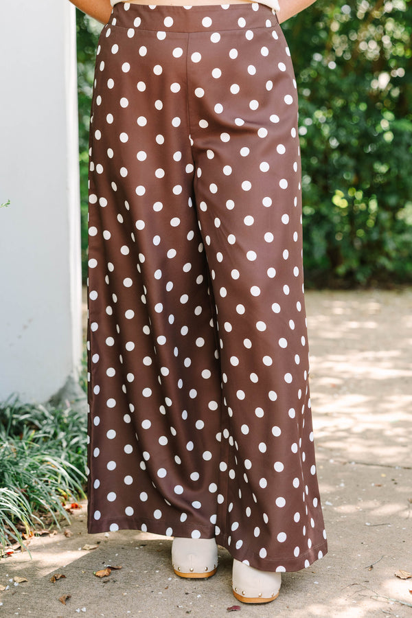 High-rise chocolate brown palazzo pants with white polka dots and a flowy wide-leg silhouette.