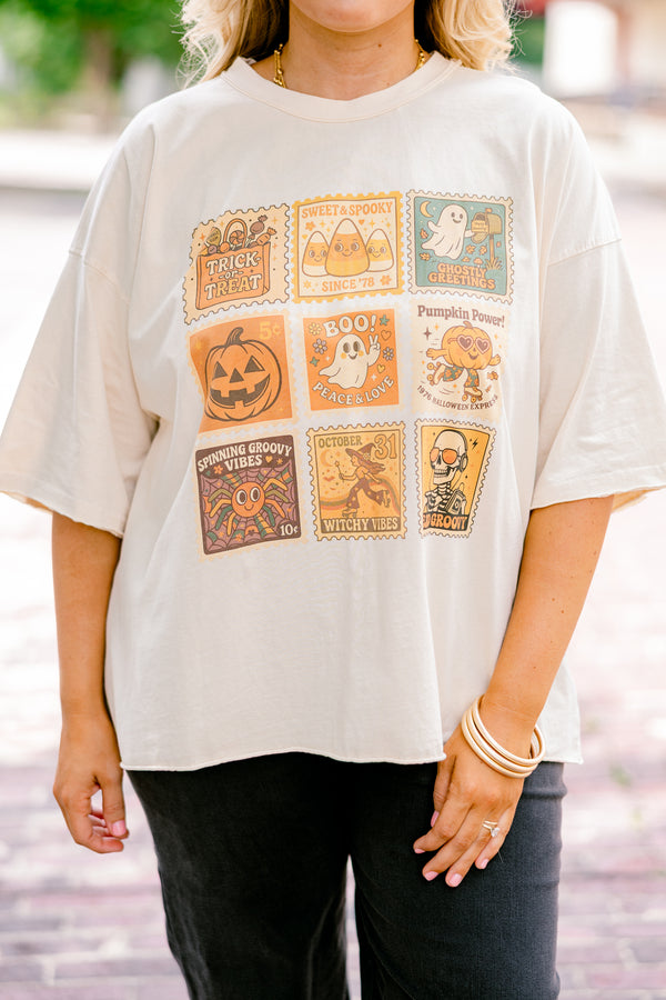 Chic Soul plus size clothing, off white, half sleeve boxy oversized tee with Halloween themed stamps on the front in shades of orange with designs like candy corn, ghosts, pumpkins, witches, and skulls