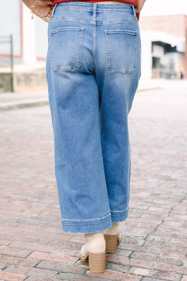 Plus Size medium wash wide-leg cropped jeans with functional pockets and a relaxed fit.
