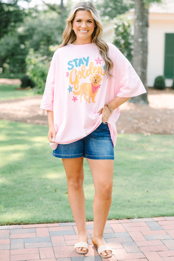 Plus size woman in a dusty pink  boyfriend tee with a golden retriever graphic.