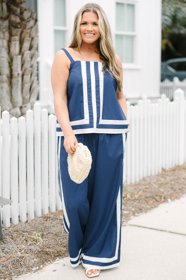 Chic Soul plus size clothing, navy blue long flowy pants with elastic waistband and drawstrings with vertical white lines down the outer sides of the pants that lead into horizontal white lines bordering the bottom of the pants