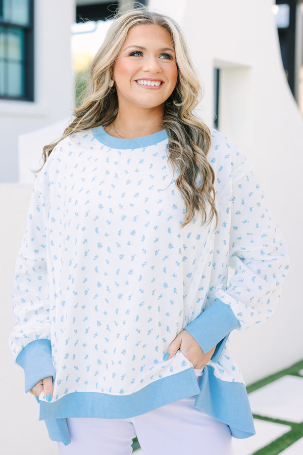 Plus Size white pullover with blue floral print, exposed seams, and a high-low hem.