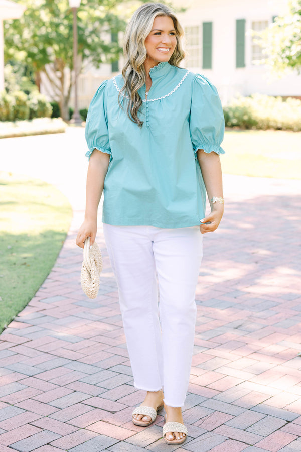 Plus Size green top with a ruffled high neck, white scalloped trim, and puff sleeves.