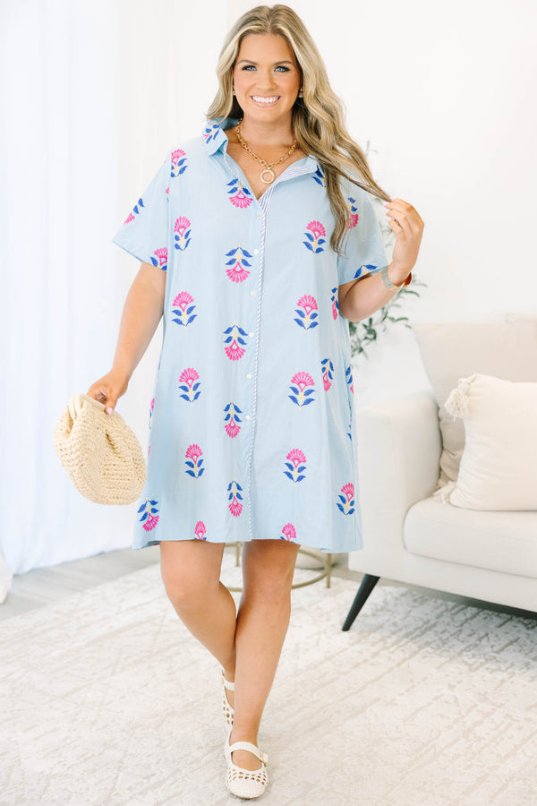 Plus size baby blue shirt dress with magenta floral embroidery, short sleeves, and a flowy fit.